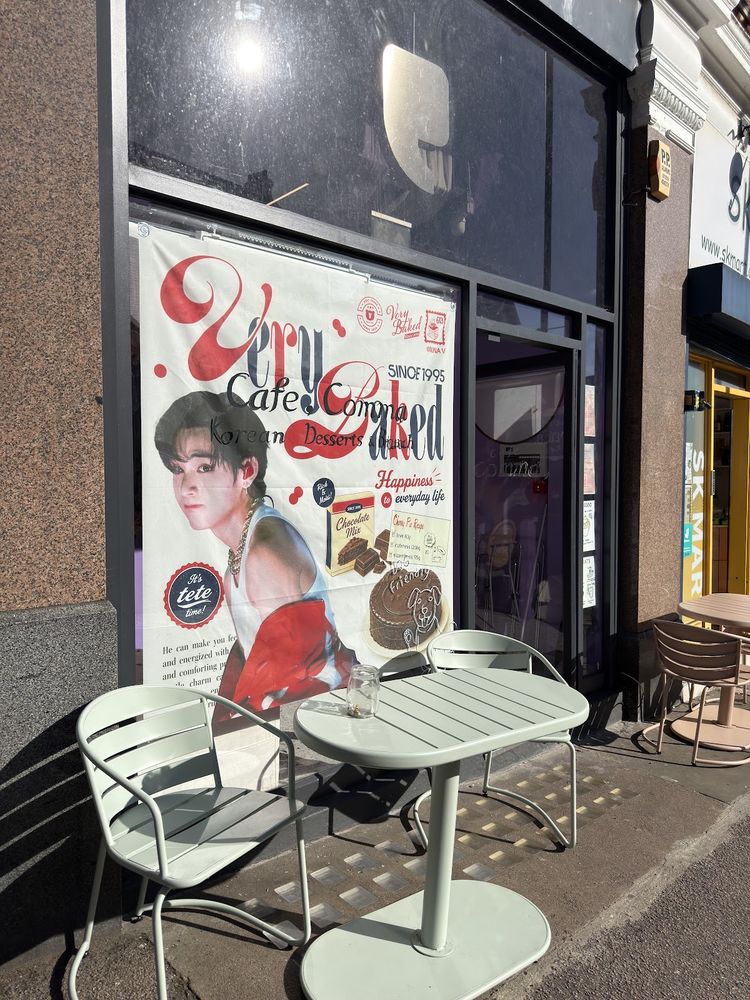 The cafe shopfront on Goldhurst Terrace with outdoor tables and chairs on the pavement, crop the burned-in words out of the frame.